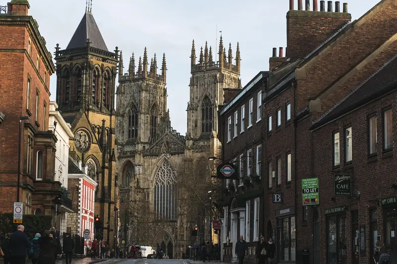 York Minster towering above a historic street lined with shops and cafés