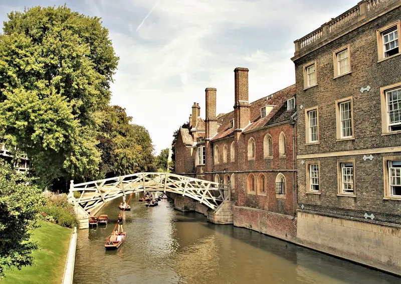 Punting boats gliding along the River Cam past Cambridge college buildings
