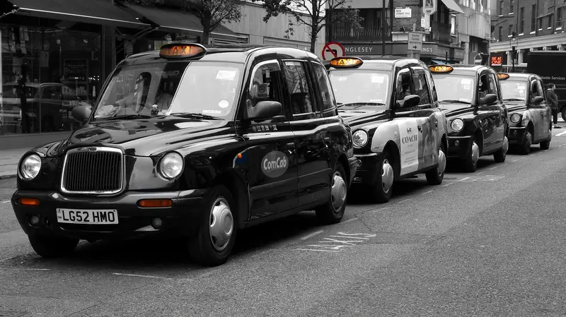 Row of classic London black cabs parked on a street