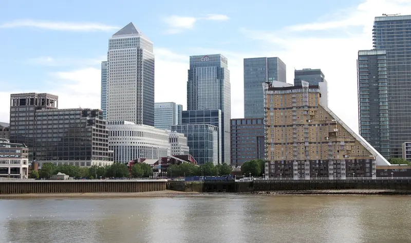 Canary Wharf business district skyline reflected in the Thames, London