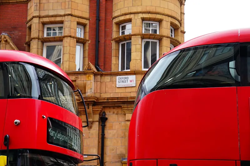 Oxford Street sign with red double-decker buses, London